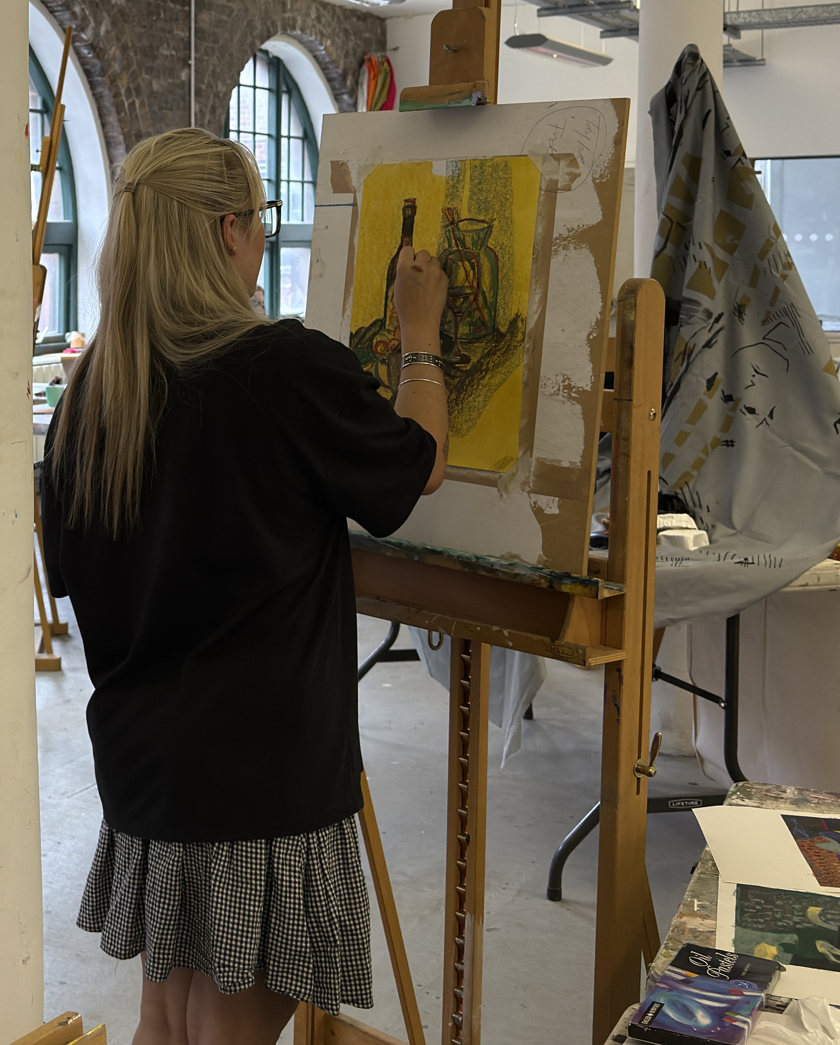 Close-up of a participant working carefully on an image during a Teal Creatives workshop.
